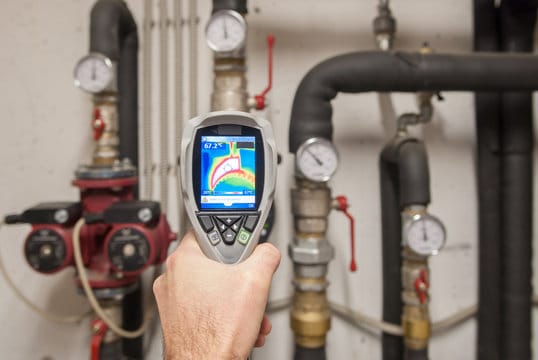 Plumber using a thermal imaging camera to inspect pipes in Englewood