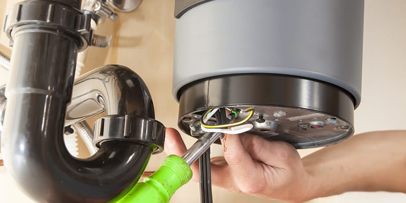Technician repairing the heating element of a water heater in Englewood