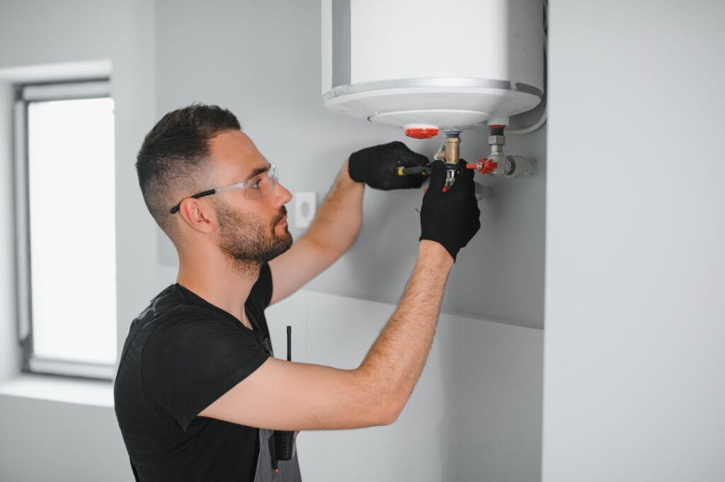 Technician performing water heater maintenance in Englewood