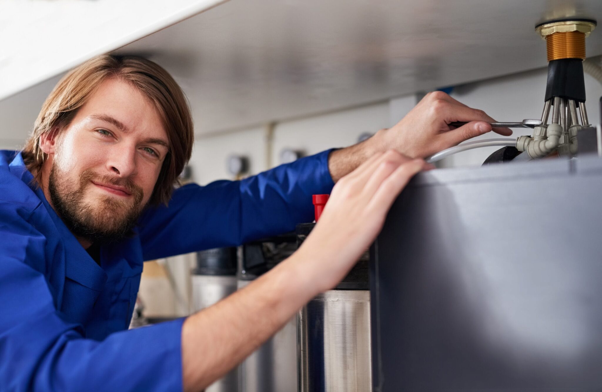 Technician servicing a residential water heater tank in Englewood